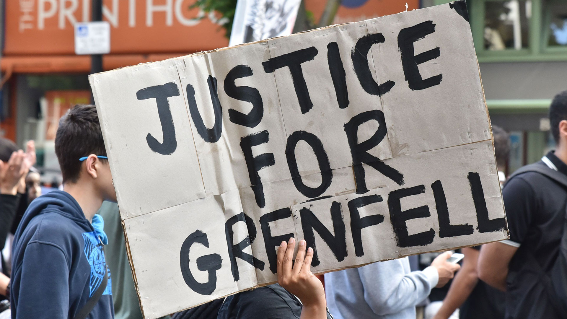 A protester holds a sign saying 'justice for Grenfell'. Michael Gove has vowed to help victims bring prosecutions.
