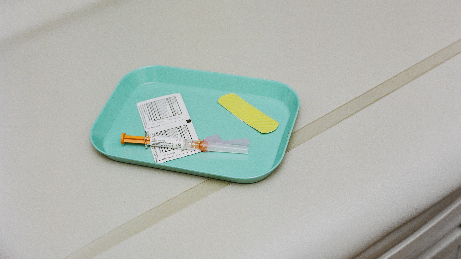 Vaccine on a tray with swabs and a band-aid