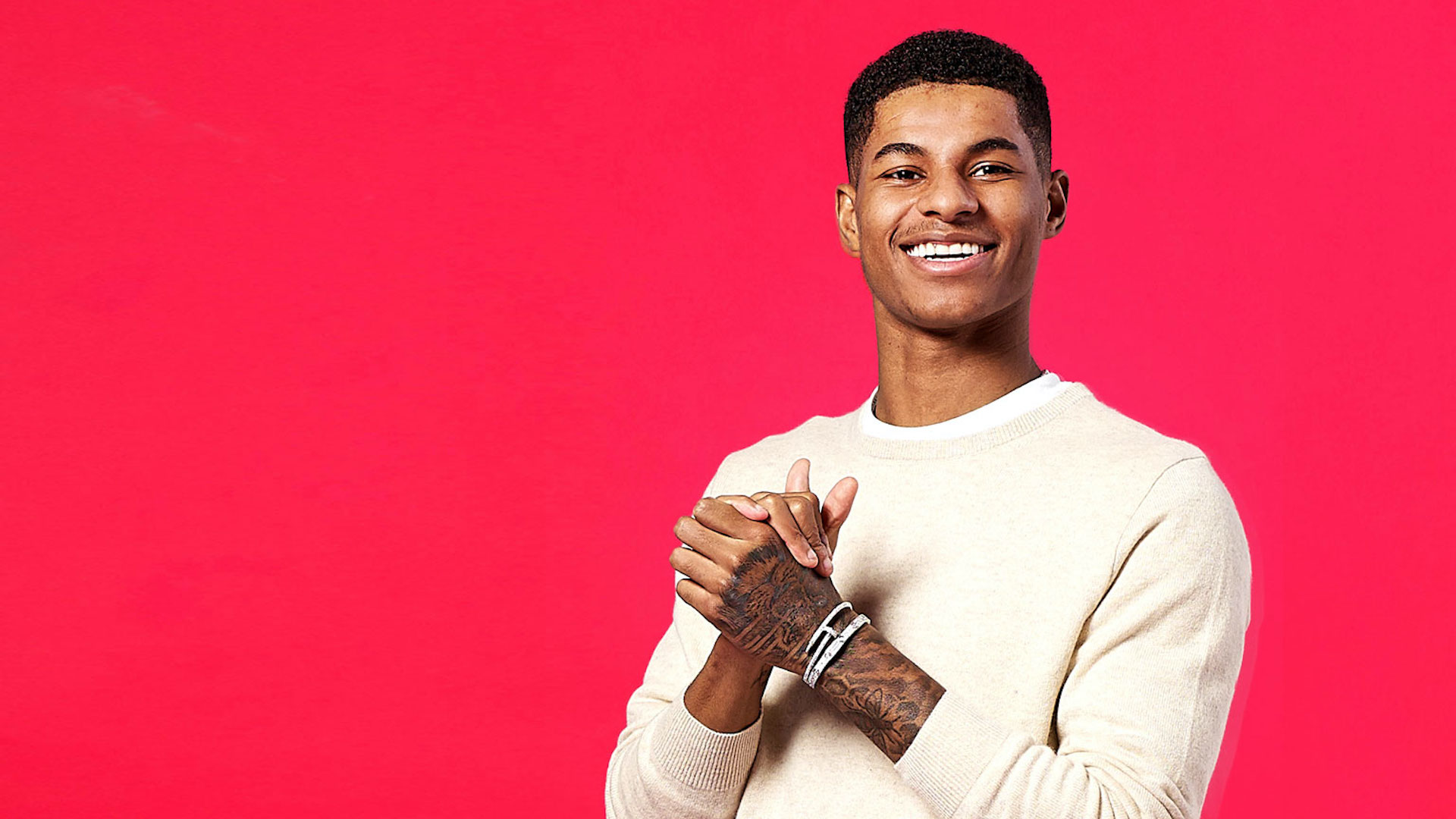 Marcus Rashford smiles and rubs his hands together