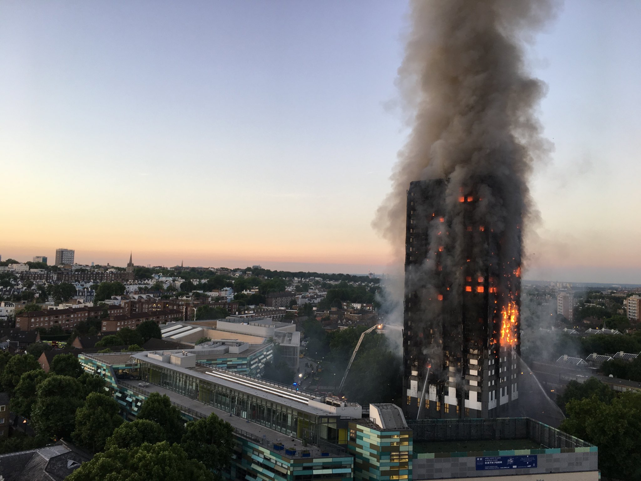 Grenfell Tower in west London burns with the city in the background.