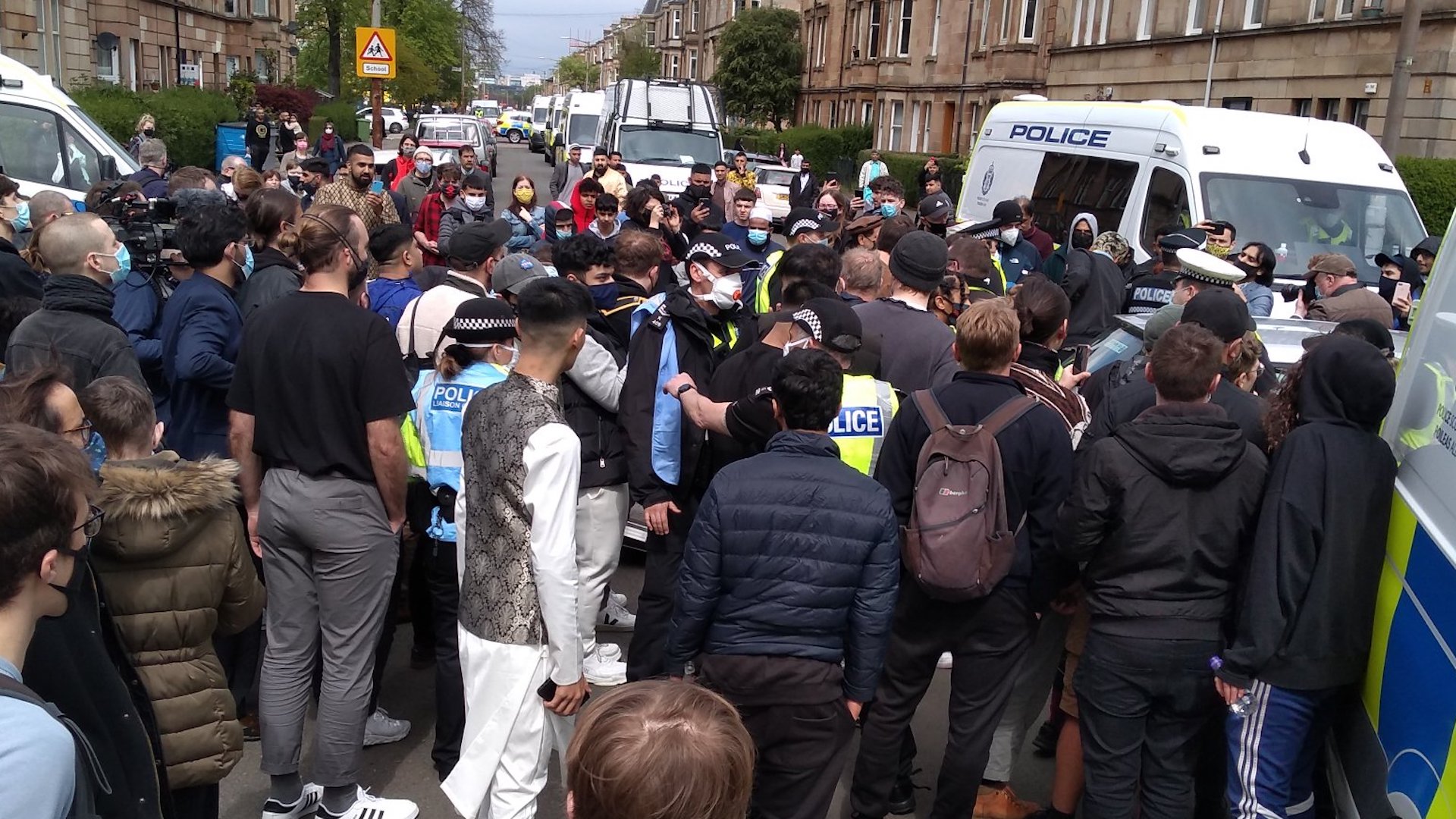 Locals surrounding the Home Office van where two people were reportedly being detained. Image: Benjamin Thomas White