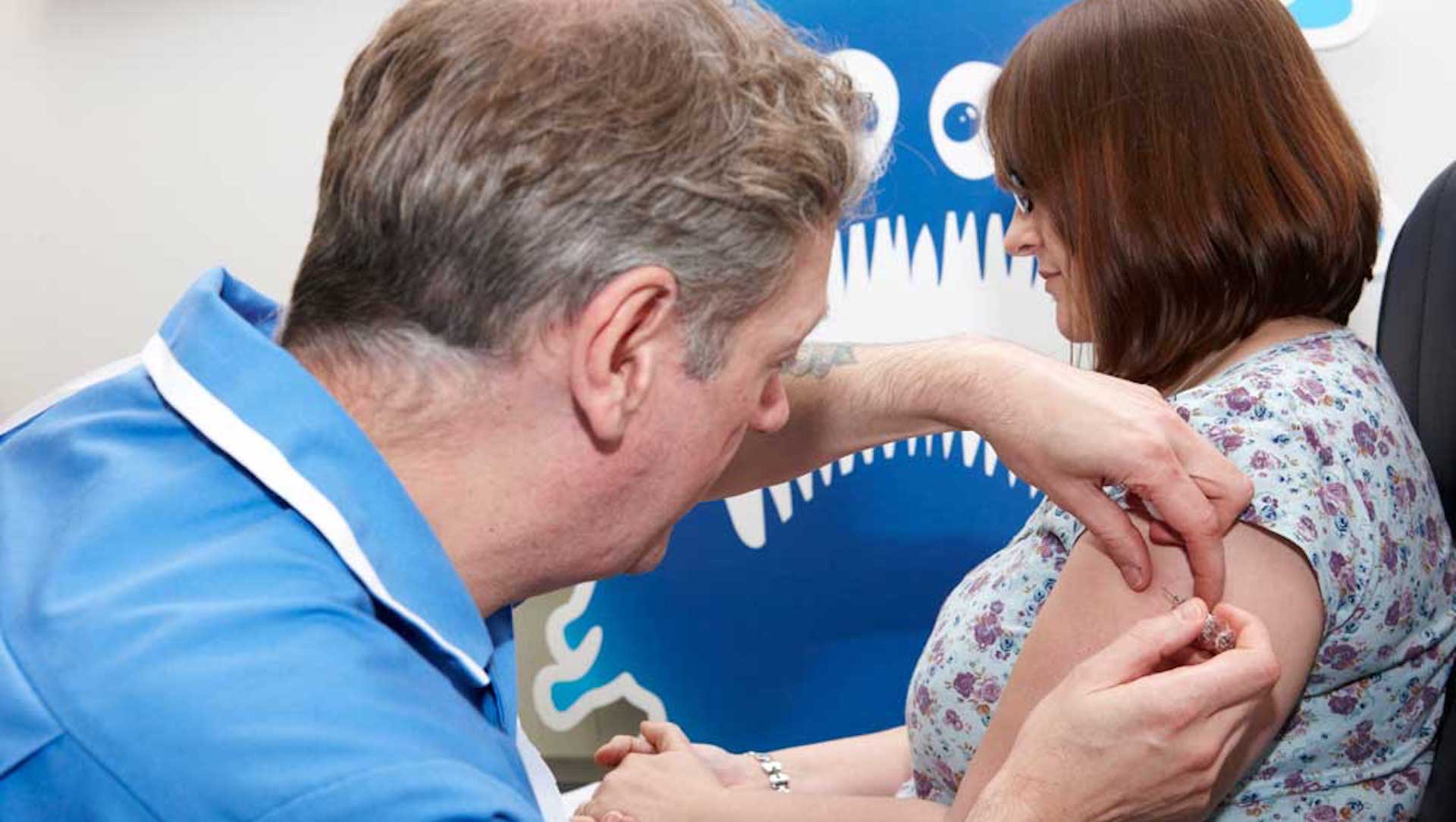A nurse gives a woman a flu jab in Scotland