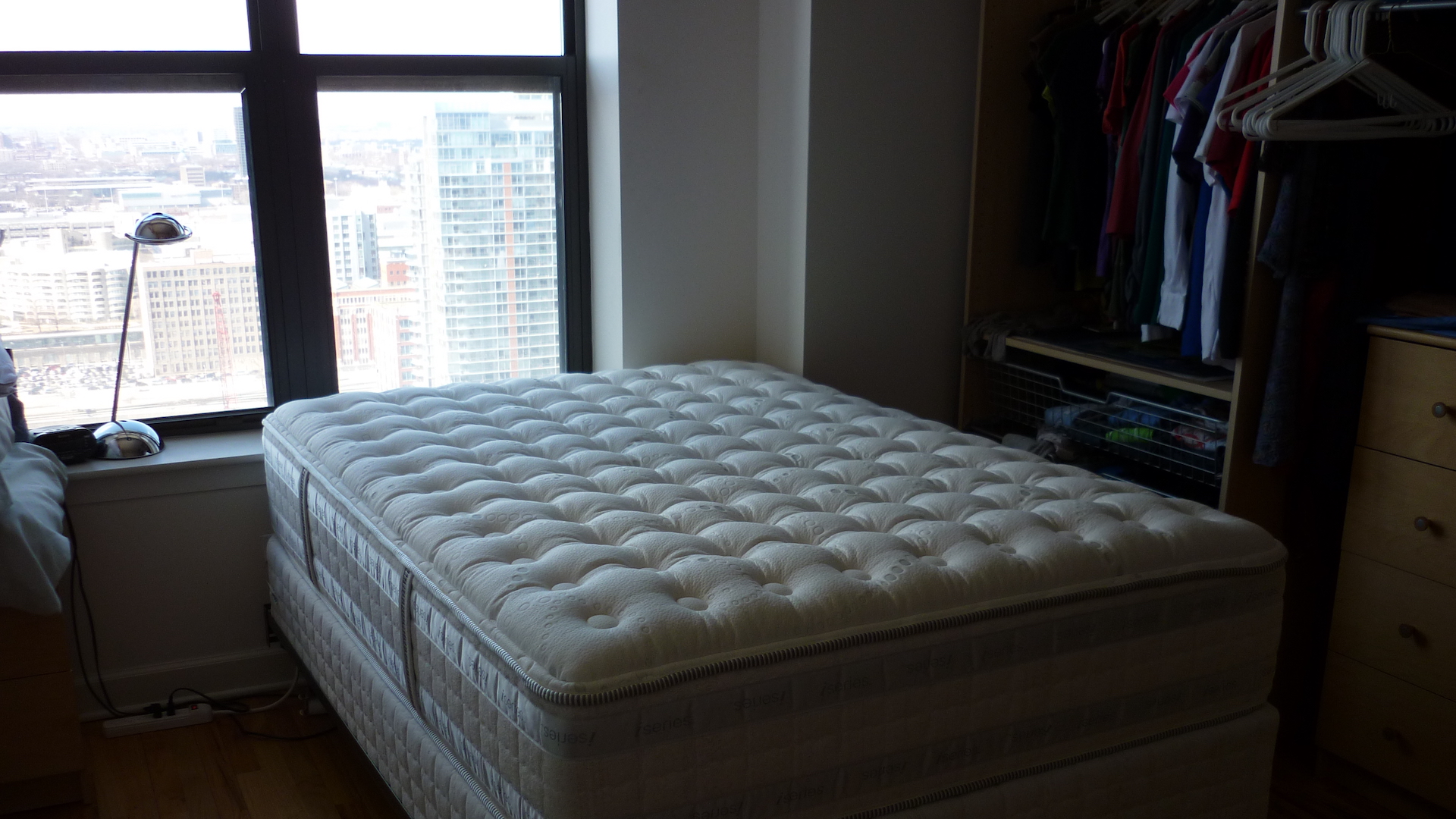 A mattress without a sheet in an apartment by the window