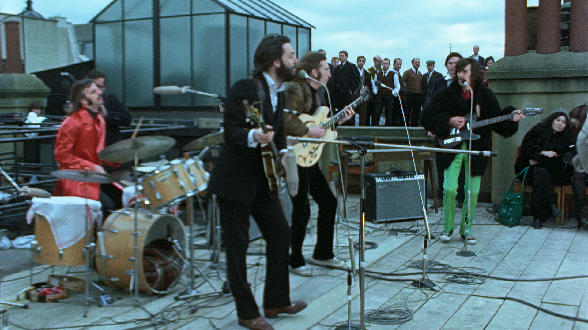 Ringo Starr, Paul McCartney, John Lennon, and George Harrison playing their famous gig on a London rooftop
