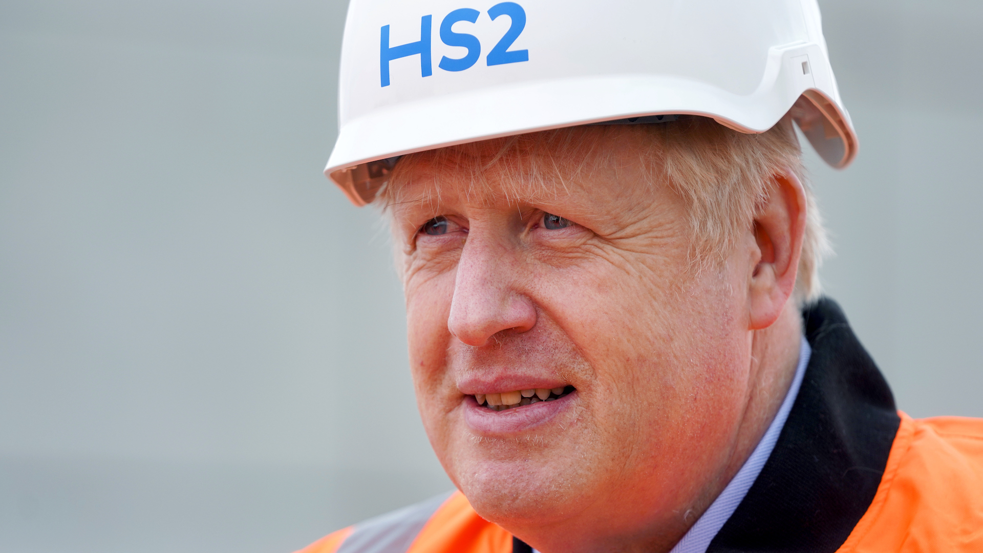 Prime minister Boris Johnson in an orange high vis jacket and a HS2 helmet