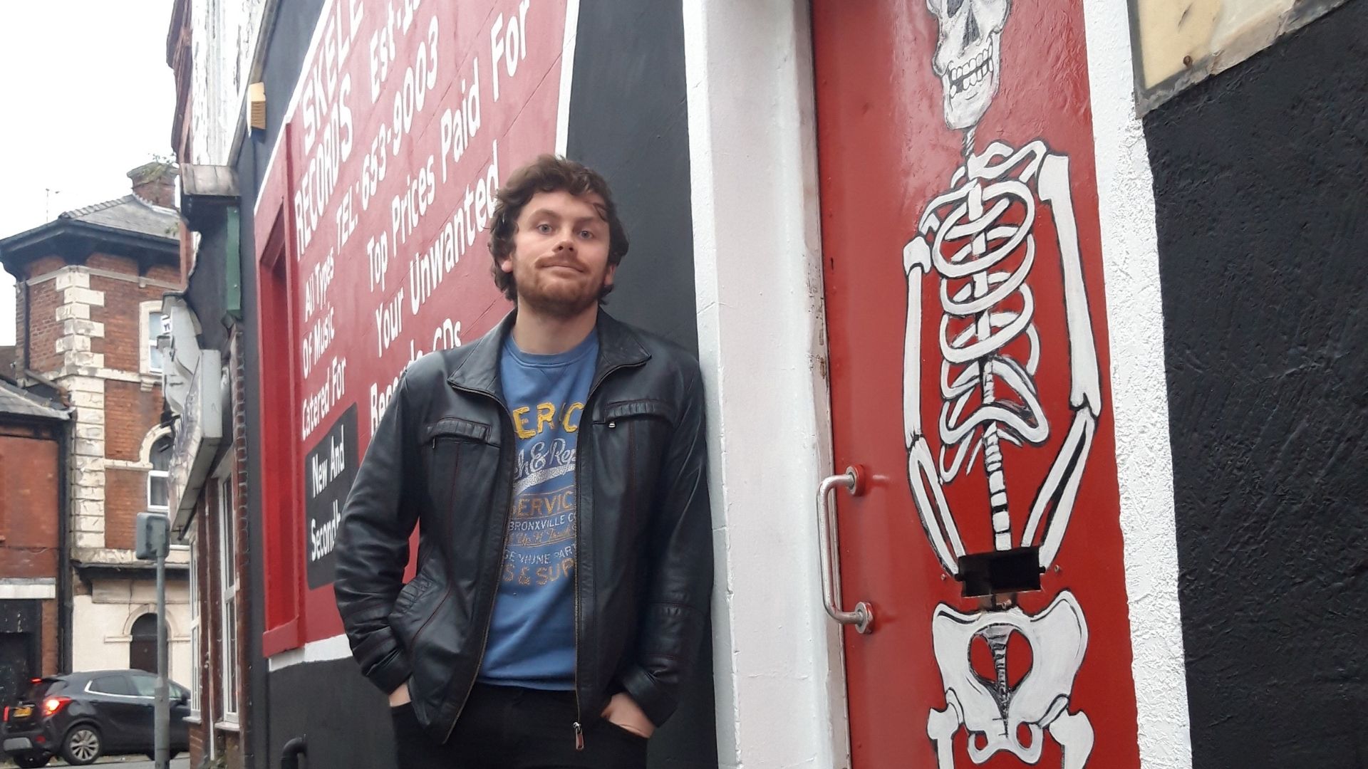 Ben Savage stands outside Skeleton Records vinyl store in Birkenhead
