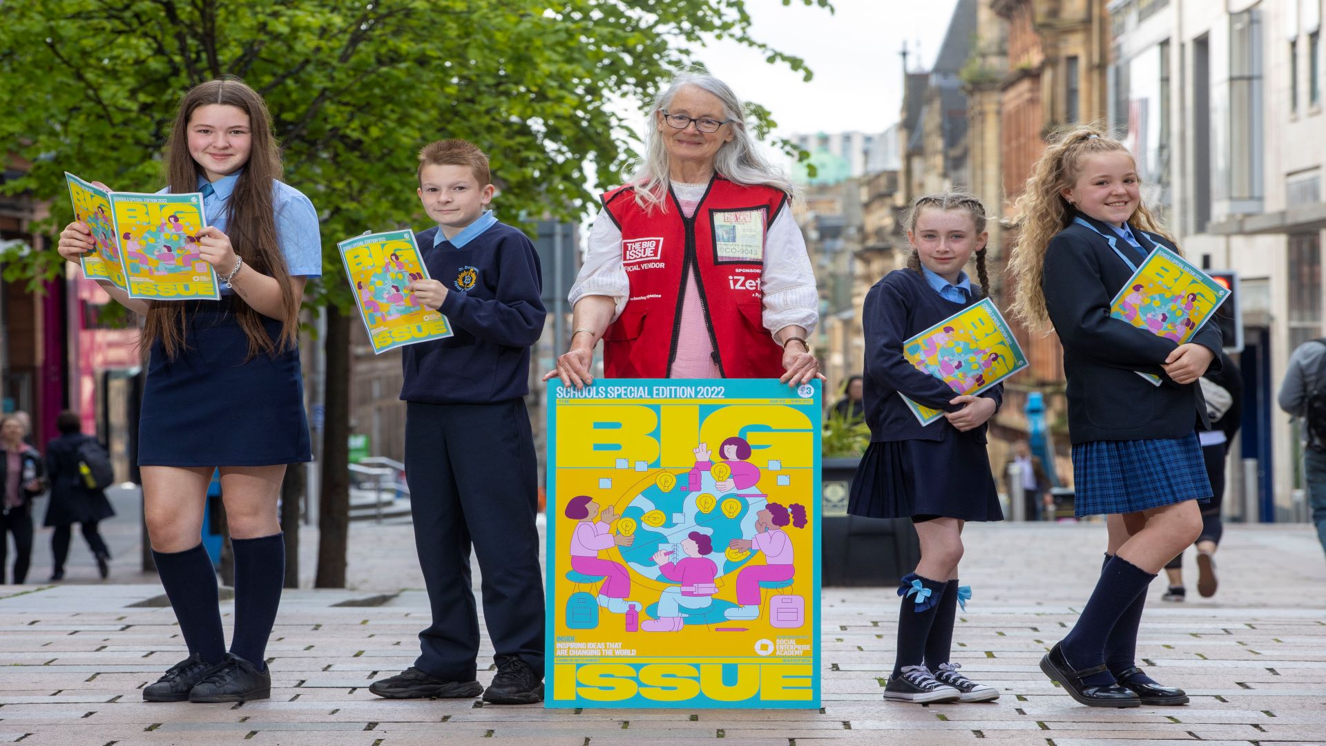 Pupil’s from St Bernard’s Primary School in Glasgow celebrate the special edition of The Big Issue in partnership with Social Enterprise Academy, with Big Issue vendor, Anabel – image Jeff Holmes