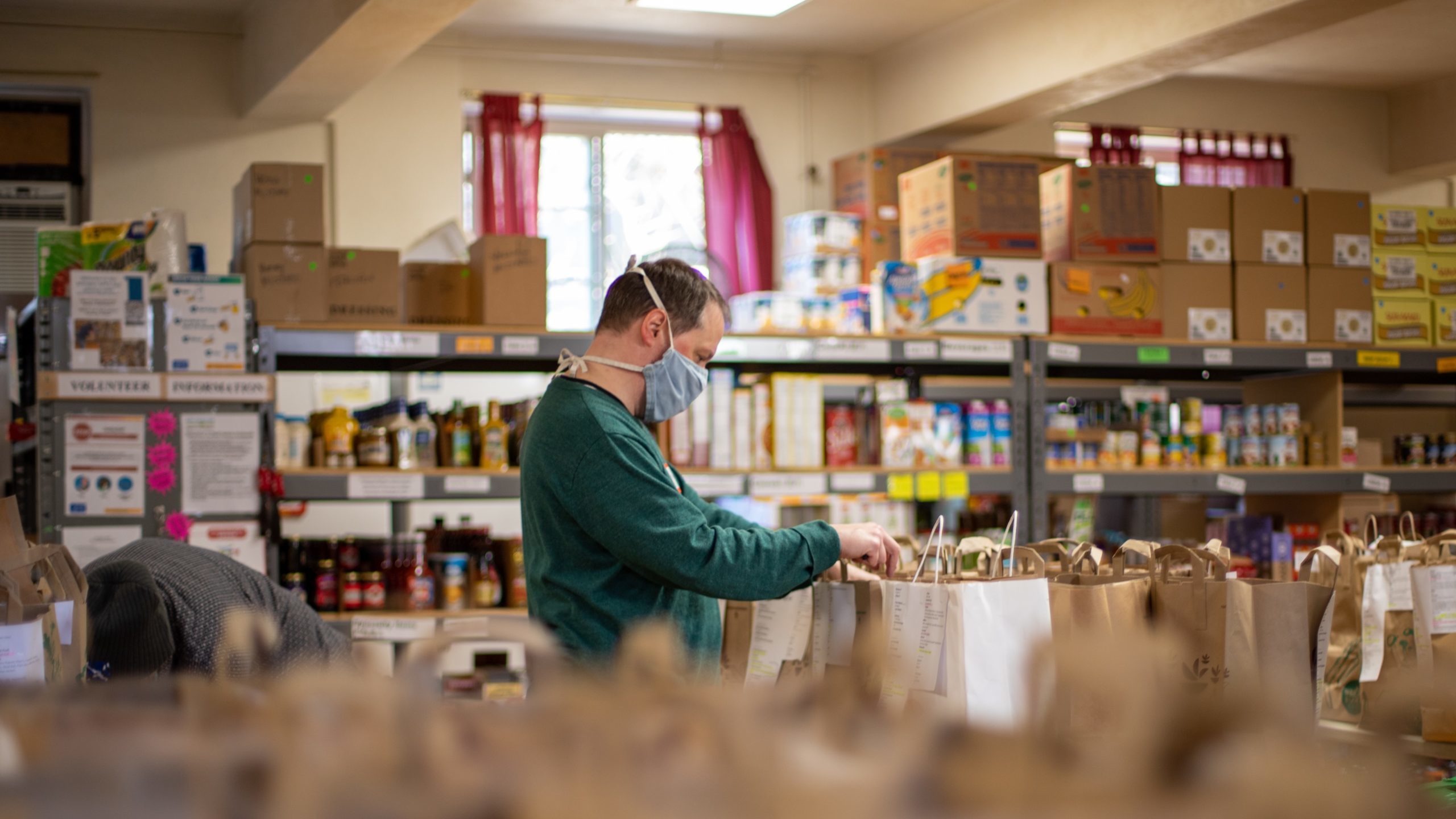 Food parcels are prepared by a volunteer at a food bank