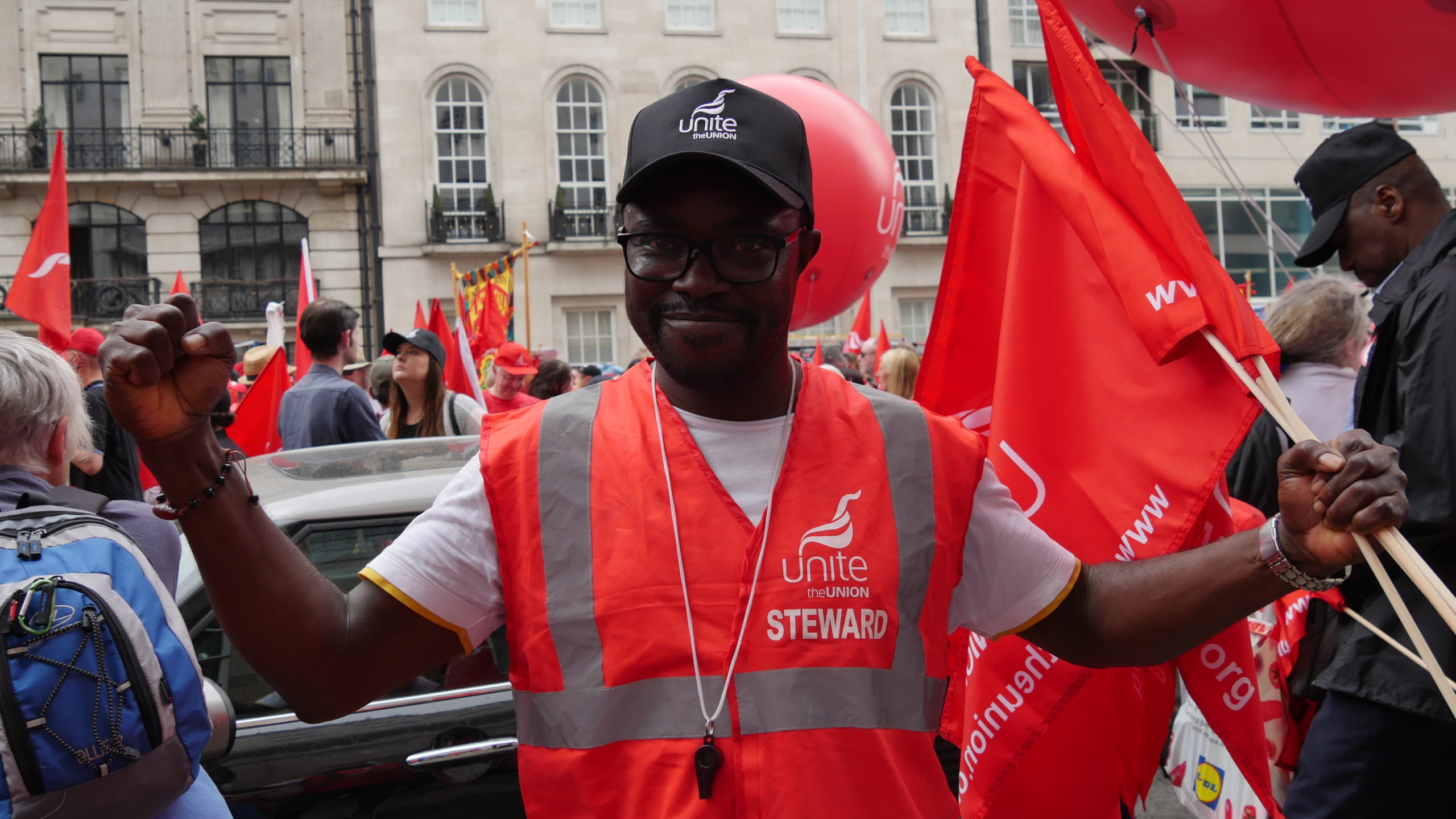 A steward for union Unite directs protestors at a rally to protest low pay in London last month