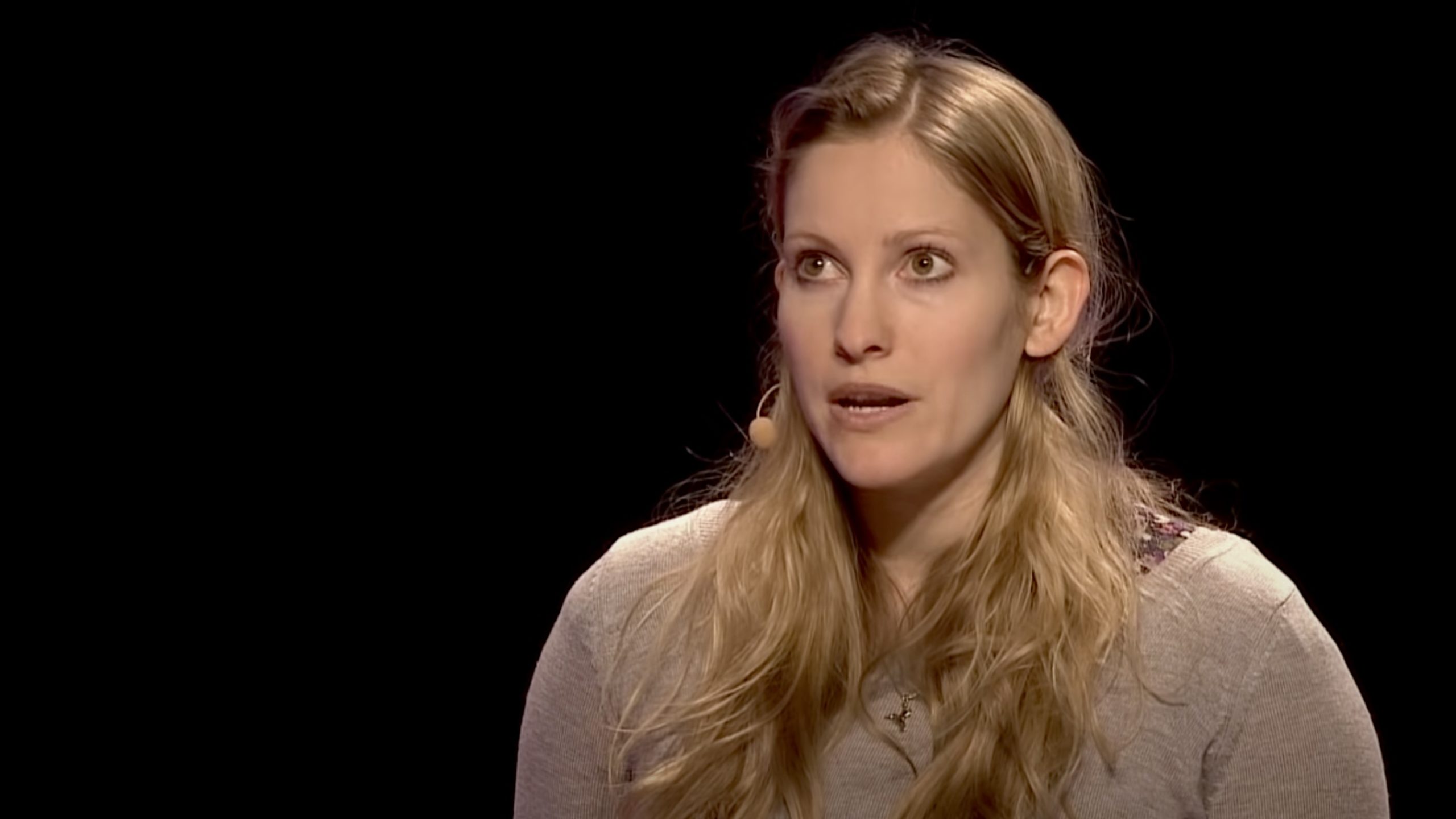 A still image of Laura Bates speaking at a Ted Talk