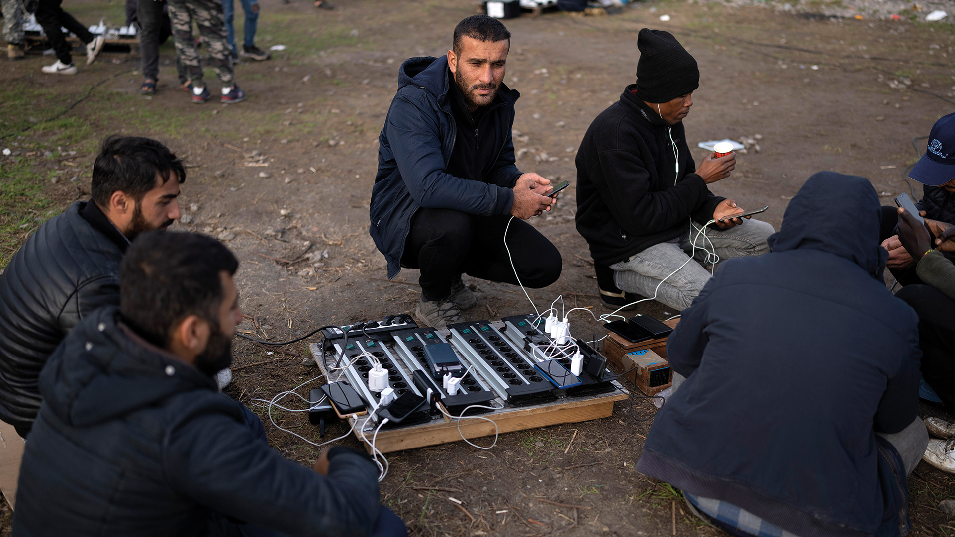 Refugees charge the phones powered by a generator from the refugee crisis charity Care4Calais on November 02, 2022 in Dunkerque, France. Photo: Christopher Furlong/Getty Images