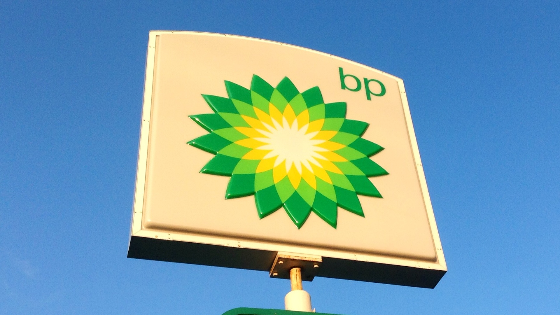A BP sign with it's yellow and green spiky circles fills the screen against a clear blue skyfills