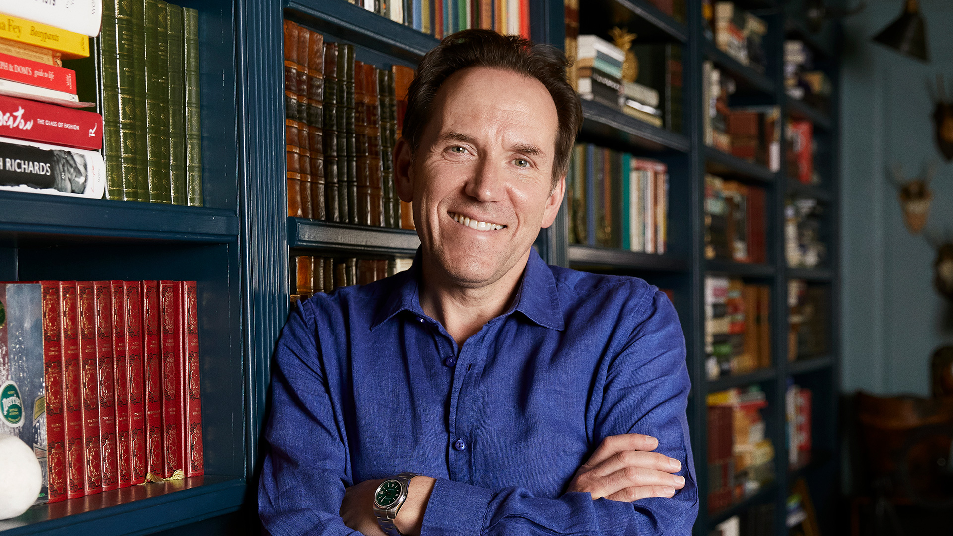 Ben Miller leaning against a bookcase