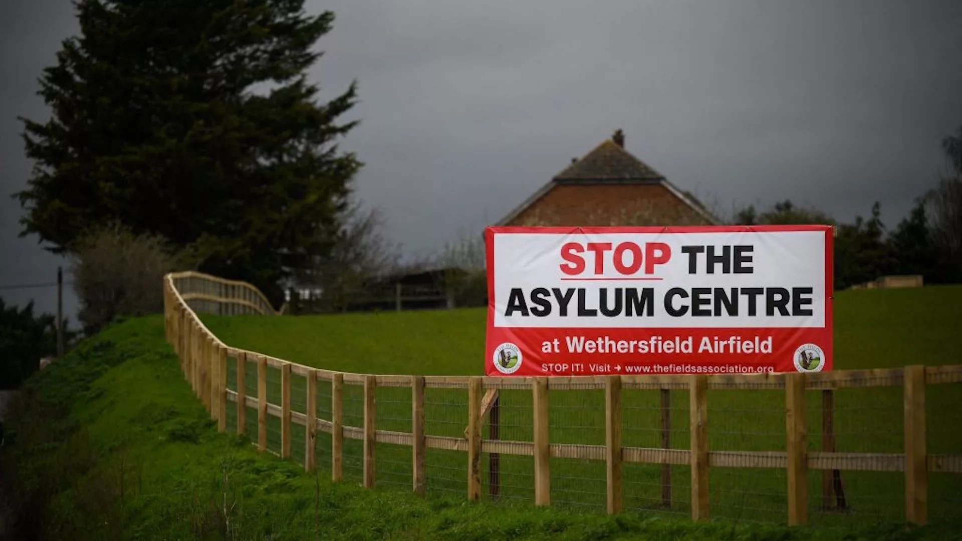 A photograph taken on March 29, 2023 shows a board reading "Stop Asylum centre" at the entrance of the village of Wethersfield where the British government is planing to house asylum seekers at a former RAF base located in the area.