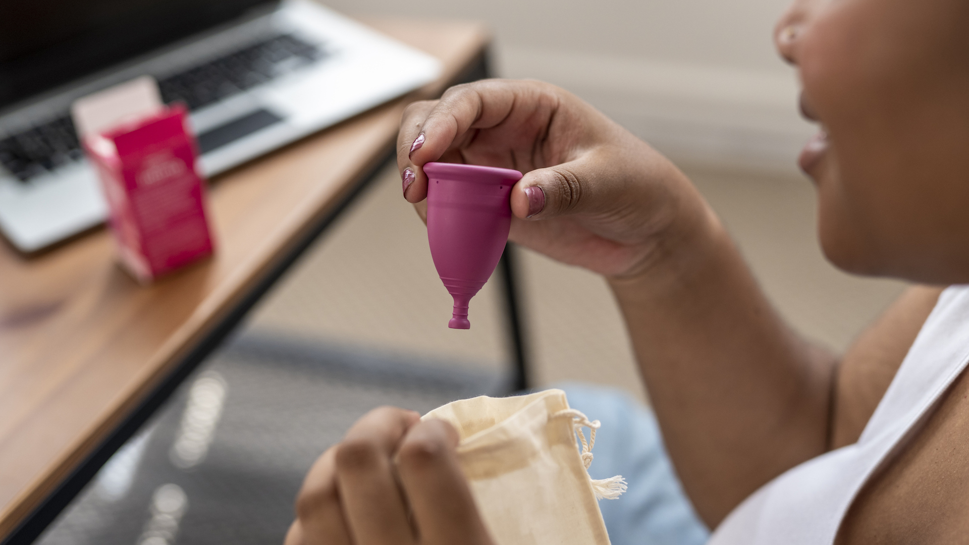 Woman taking a menstrual cup out of the bag.
