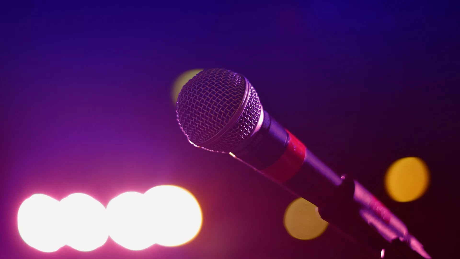 A microphone with stage lights in the background