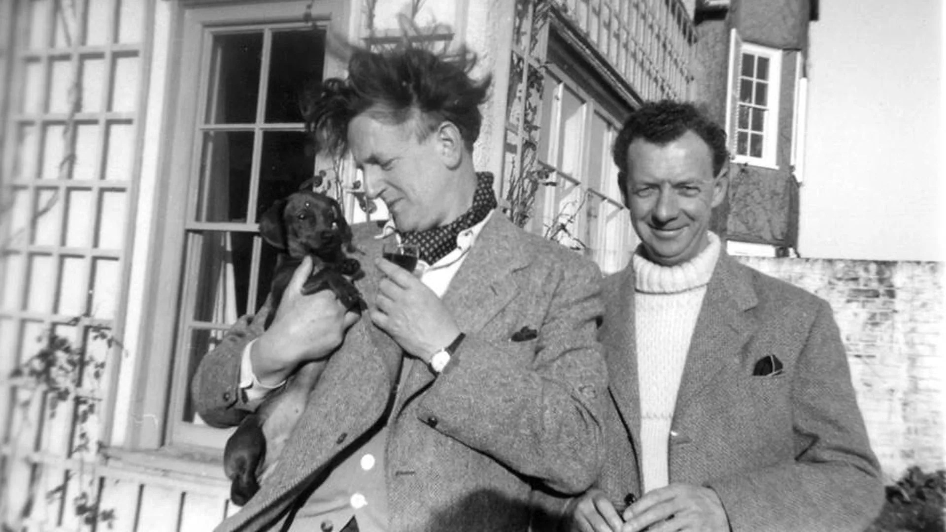 Pears and Britten outside Crag House with their dog Jove as a puppy. Photographer: unknown