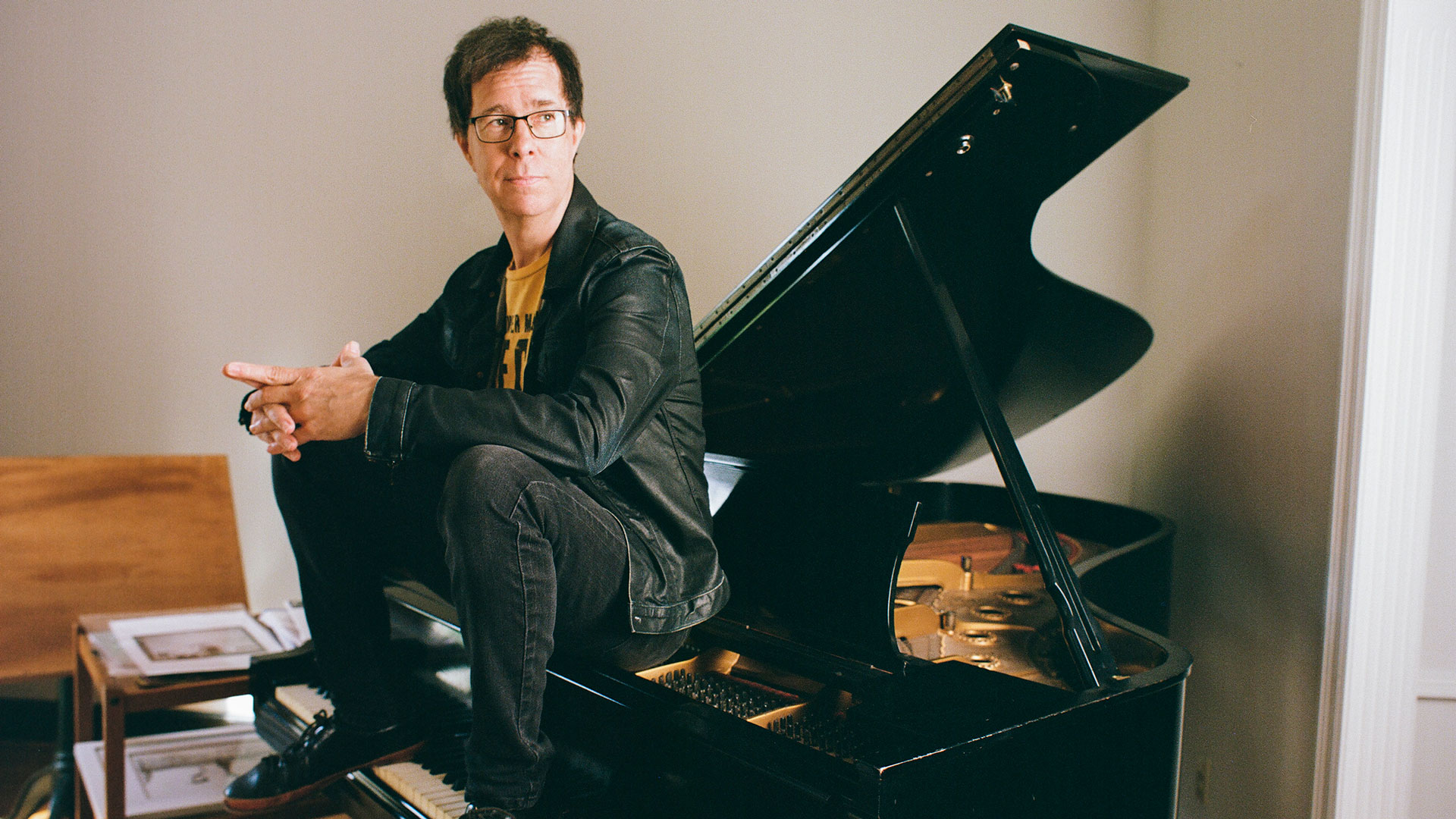 Ben Folds sitting on a piano