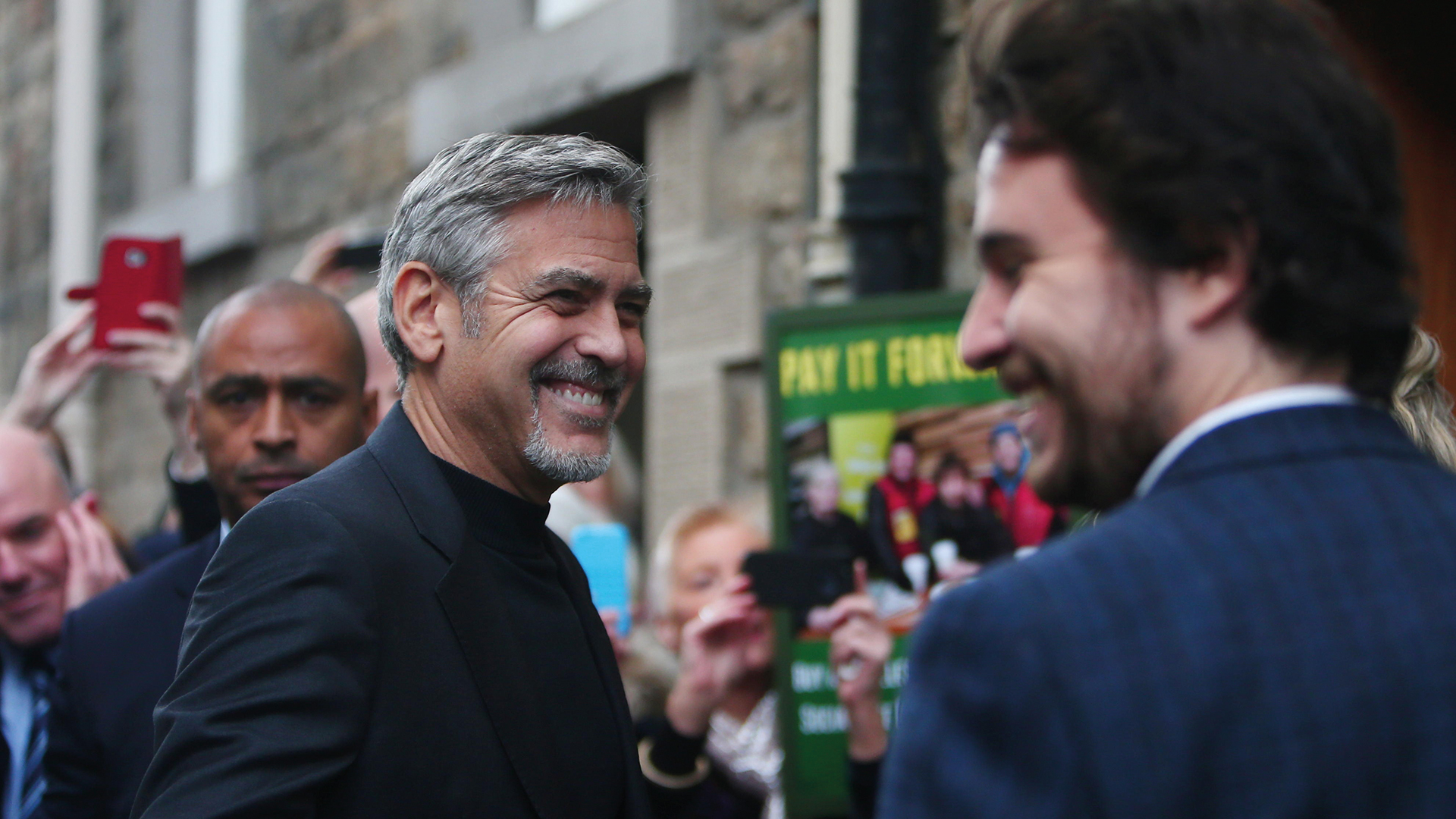 Josh Littlejohn smiling as he greets George Clooney at Social Bite’s cafe on Rose Street