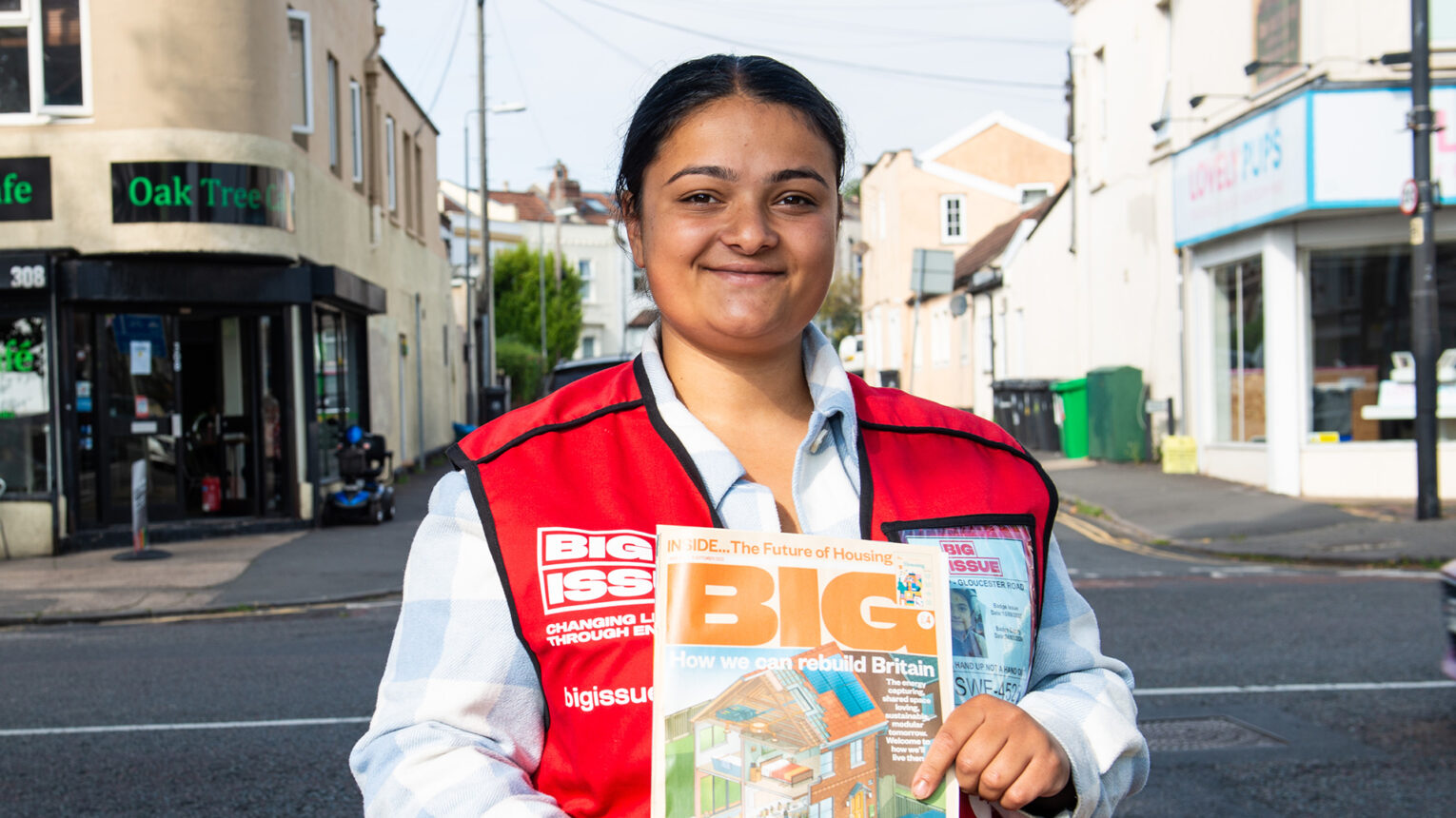 Big Issue vendor Daiana in the street holding a magazine