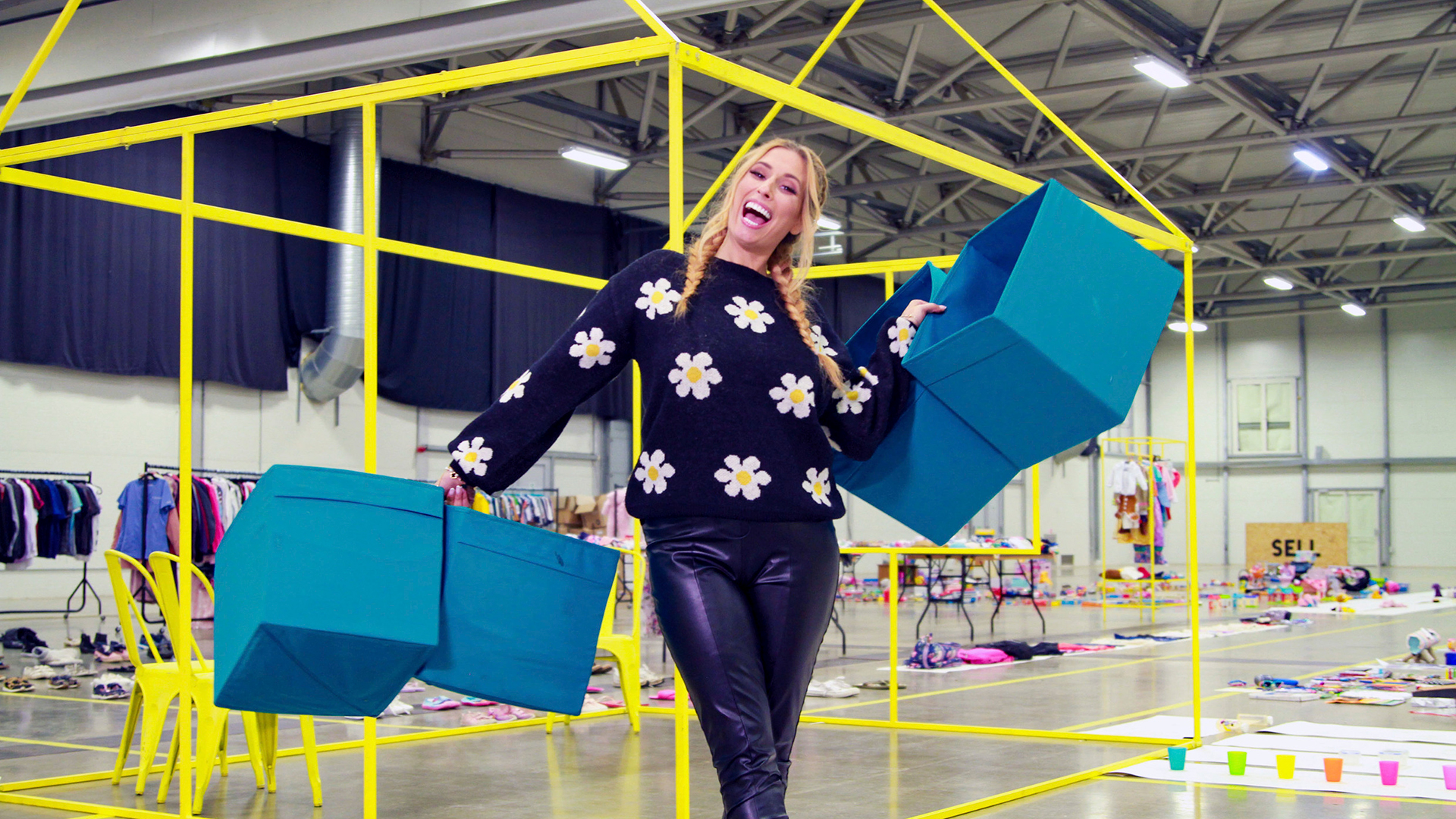 Stacey Solomon in a warehouse holding boxes