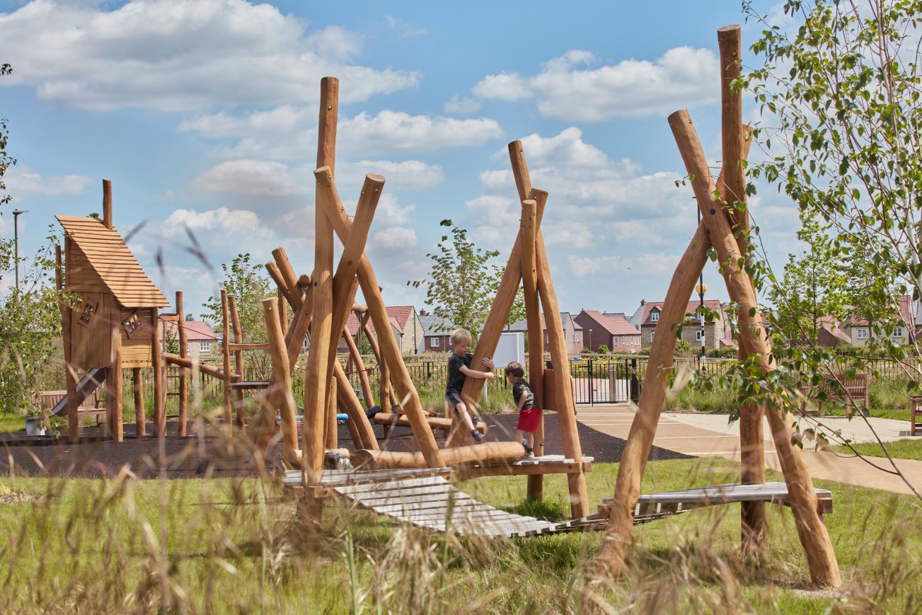 Wooden playset in a meadow setting, with children playing