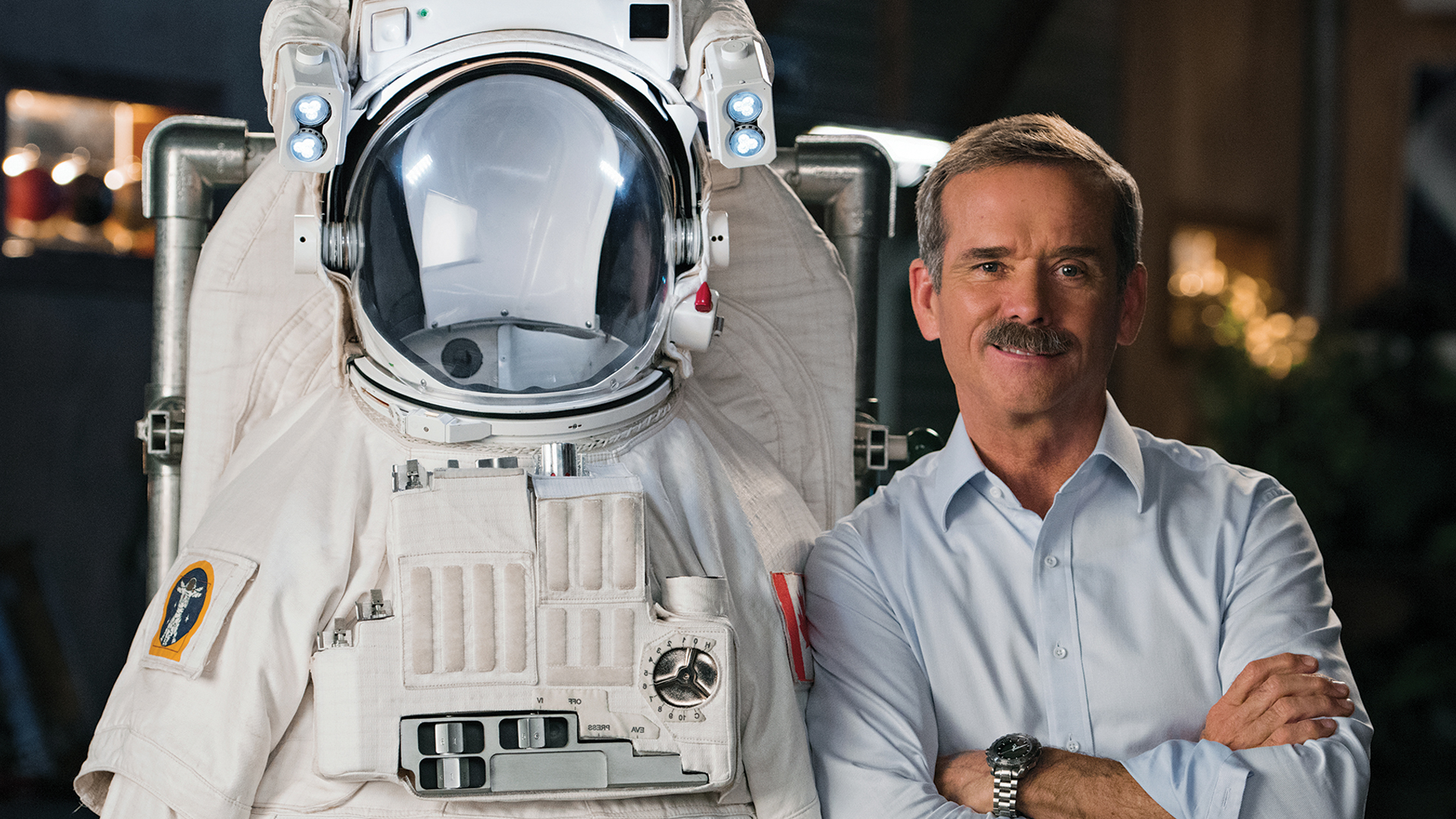 Chris Hadfield next to an astronaut's suit